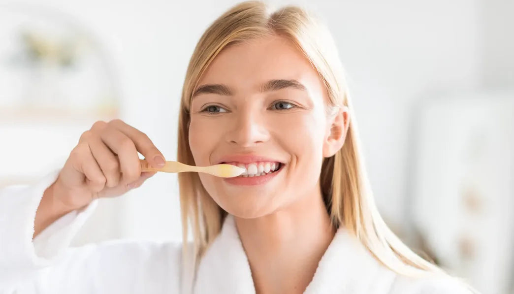 Smiling woman brushing her teeth